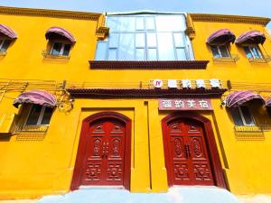 a yellow building with red doors and windows at Xinjiang Rhythm Hotel-疆韵民宿 in Kashgar