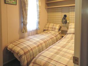 two beds sitting next to each other in a room at Windy Roost Lodge in Tydd Saint Giles