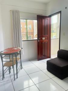 a living room with a table and a couch at Aldenora Flats in Fortaleza