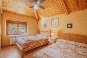 a bedroom with two beds and a ceiling fan at Sanz in Castro de Fuentidueña +19 photos