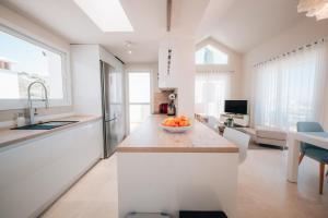 a kitchen with a bowl of fruit on a counter at Frontline Golf Penthouse Lagoon & SPA – EHHouse in Estepona