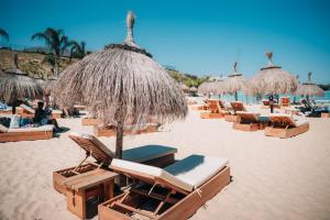 a group of chairs and umbrellas on a beach at Frontline Golf Penthouse Lagoon & SPA – EHHouse in Estepona