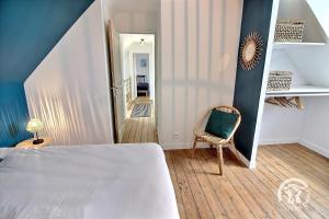 a bedroom with a bed and a chair and a staircase at Ty jaudy in Trédarzec