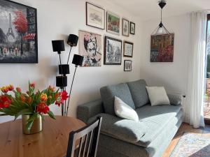 a living room with a couch and a table with flowers at Gallery - Terrasse mit Seeblick und Garten in Altmünster