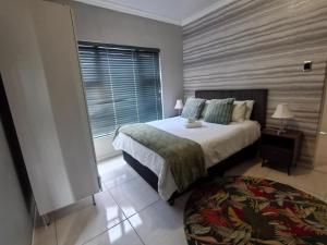 a bedroom with a bed and a large window at Mabee's Place in Durban