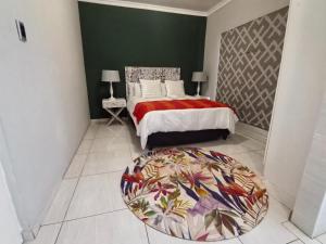 a bedroom with a bed with a colorful rug on the floor at Mabee's Place in Durban