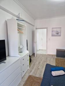 a living room with a white dresser and a tv at Iraklia Pearl in Nea Irakleia
