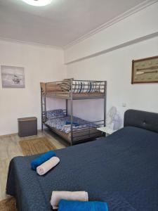 a bedroom with two bunk beds and a blue bed at Iraklia Pearl in Nea Irakleia