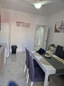 a kitchen with a white table and a white refrigerator at Iraklia Pearl in Nea Irakleia
