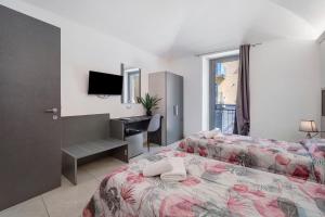 a bedroom with a bed and a desk and a television at Affitta Camere Novara in Novara