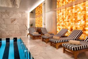 a row of chairs and a pool in a room at Radisson Collection Astorija Hotel, Vilnius in Vilnius