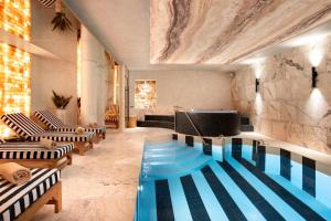 a pool in a room with chairs and a couch at Radisson Collection Astorija Hotel, Vilnius in Vilnius