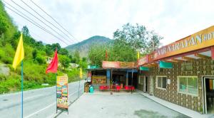 a building on the side of a road with flags at Hotel NAR NARAYANA in Chutwāpīpal