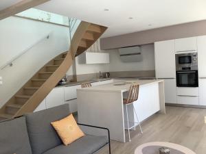 a kitchen and living room with a staircase in a house at La maisonnette de colette in Chastel-Nouvel +4 photos