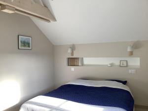 a bedroom with a bed in a white room at La maisonnette de colette in Chastel-Nouvel