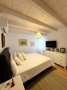 a bedroom with a white bed and a television at Posadas de Marí Casa Andreea 6 in Talavera de la Reina