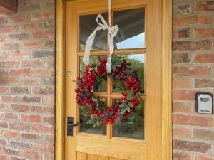 a christmas wreath on the door of a house at Winship Cottage in Winestead