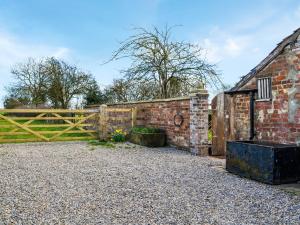 a brick building with a gate and a fence at Winship Cottage in Winestead