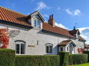 a white house with a red roof at Winship Cottage in Winestead