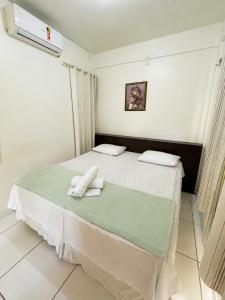 a bedroom with a bed with two towels on it at Aldenora Flats in Fortaleza