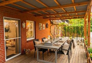 a patio with a table and chairs on a deck at Ferienwohnungen Auetal in Kucksdorf