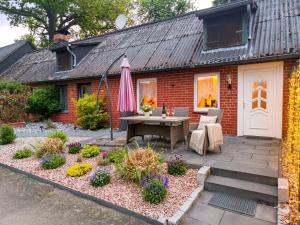 a patio with a table and an umbrella in front of a house at Ferienwohnungen Auetal in Kucksdorf