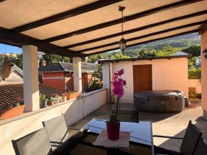 a patio with a table and chairs and a barrel at Apartman Jesenjin Pobri in Volosko