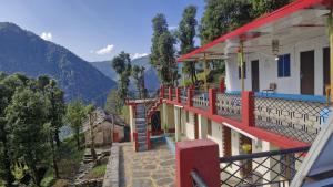 a house with a red stair case on a balcony at The Captain's Quarters in Ukhimath