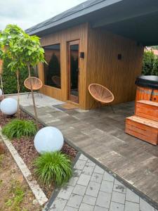 a patio with two chairs and a house at LUX HOUSE Roztocze Sauna i Bania z hydromasażem in Krasnobród