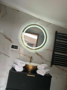 a bathroom with a sink and a mirror and towels at LUX HOUSE Roztocze Sauna i Bania z hydromasażem in Krasnobród