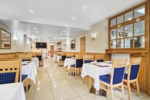 a dining room with white tables and chairs at Best Western London Ilford Hotel in Ilford