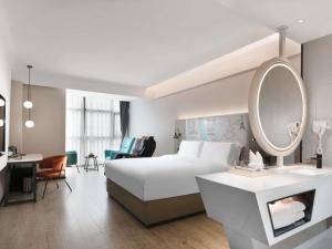 a hotel room with a bed and a mirror at Mercure Chengdu Xindu in Chengdu