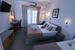 a bedroom with a bed with two stuffed animals on it at Astri Hotel in Neos Marmaras