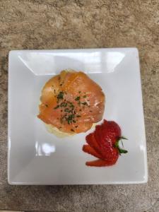 a plate of food with a strawberry on a table at No 27 in Inverness
