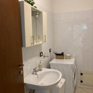 a white bathroom with a sink and a mirror at Casa Vacanza Margherita in Assemini