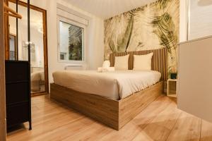 a bedroom with a large bed and a painting on the wall at La Cave Voutée - Home Cinema in Valence