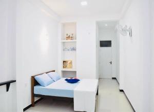 a white room with a bed and a couch at Lodge 52 in Negombo