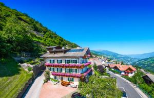 a house on the side of a hill with a road at haus urban B&B in Barbiano