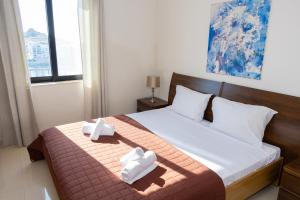 a bedroom with a bed with two towels on it at Marsalforn Panorama Penthouse in Marsalforn