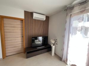 a living room with a television and a door at Apartman Irena in Pula