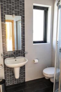 a bathroom with a sink and a toilet at Marsalforn Panorama Penthouse in Marsalforn +12 photos