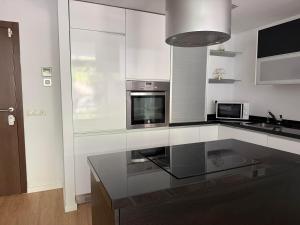 a kitchen with a glass counter top and a stove at Loft Elegante Norte de Madrid in San Sebastián de los Reyes +6 photos
