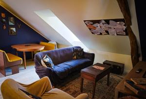 a living room with a blue couch and a table at Le refuge des explorateurs - chasse au trésor in La Flèche