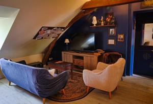 a living room with two chairs and a television at Le refuge des explorateurs - chasse au trésor in La Flèche