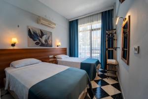 a hotel room with two beds and a window at The Turunç INN Otel in Turunç