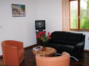 a living room with a couch and a table with flowers at Casa bianca in La Horgne