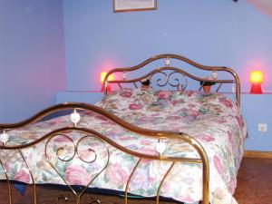 a bed with a floral comforter in a bedroom at Casa bianca in La Horgne