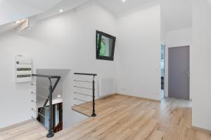 an empty room with white walls and a wooden floor at Duplex la source Amelie in Saint-Pancrasse