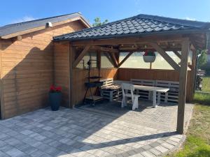 a wooden pavilion with a table and chairs on a patio at Gregorek in Ostrowo