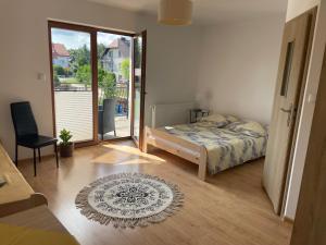 a bedroom with a bed and a door to a balcony at Gregorek in Ostrowo